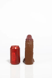 A product photo of a small realistic brown dildo.