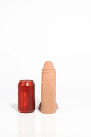 A product photo of a small tan curved dildo.