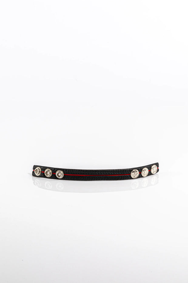 A product photo of a black cock ring with a red trim.
