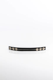 A product photo of a black cock ring with white trim.