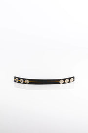 A product photo of a black leather cock ring with yellow trim.
