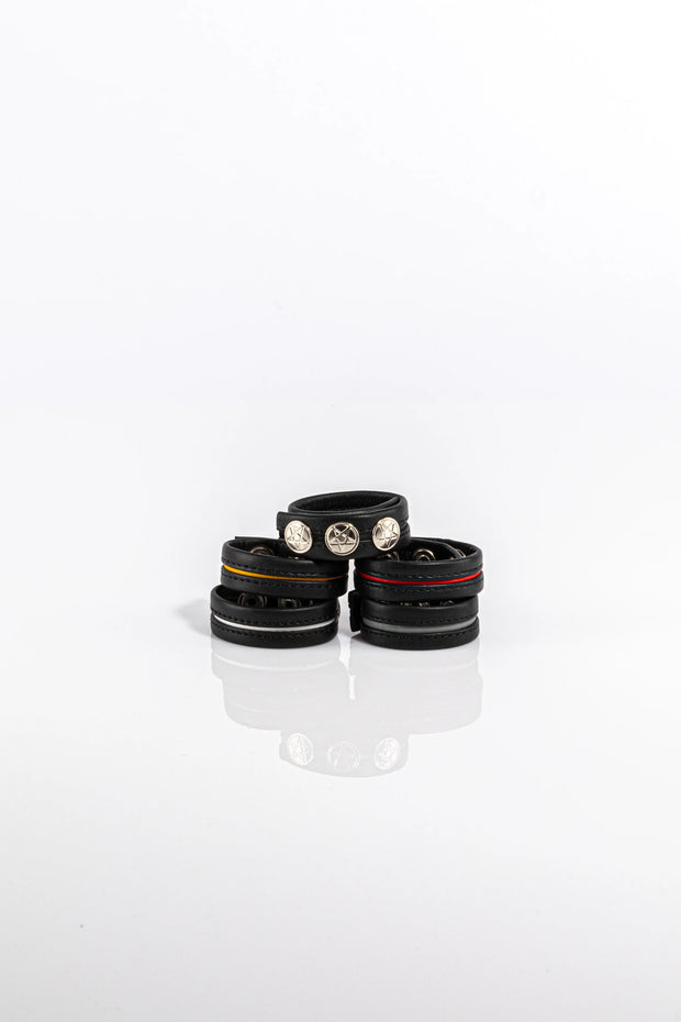 A product photo of five black and coloured cock rings. 