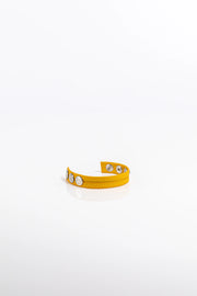 A product photo of a solid yellow leather cock ring.