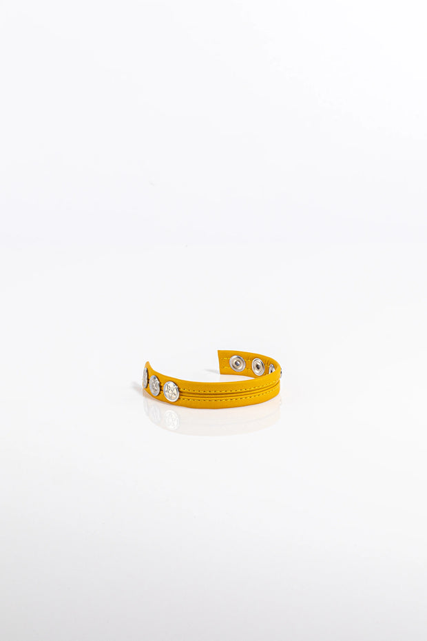 A product photo of a solid yellow leather cock ring.
